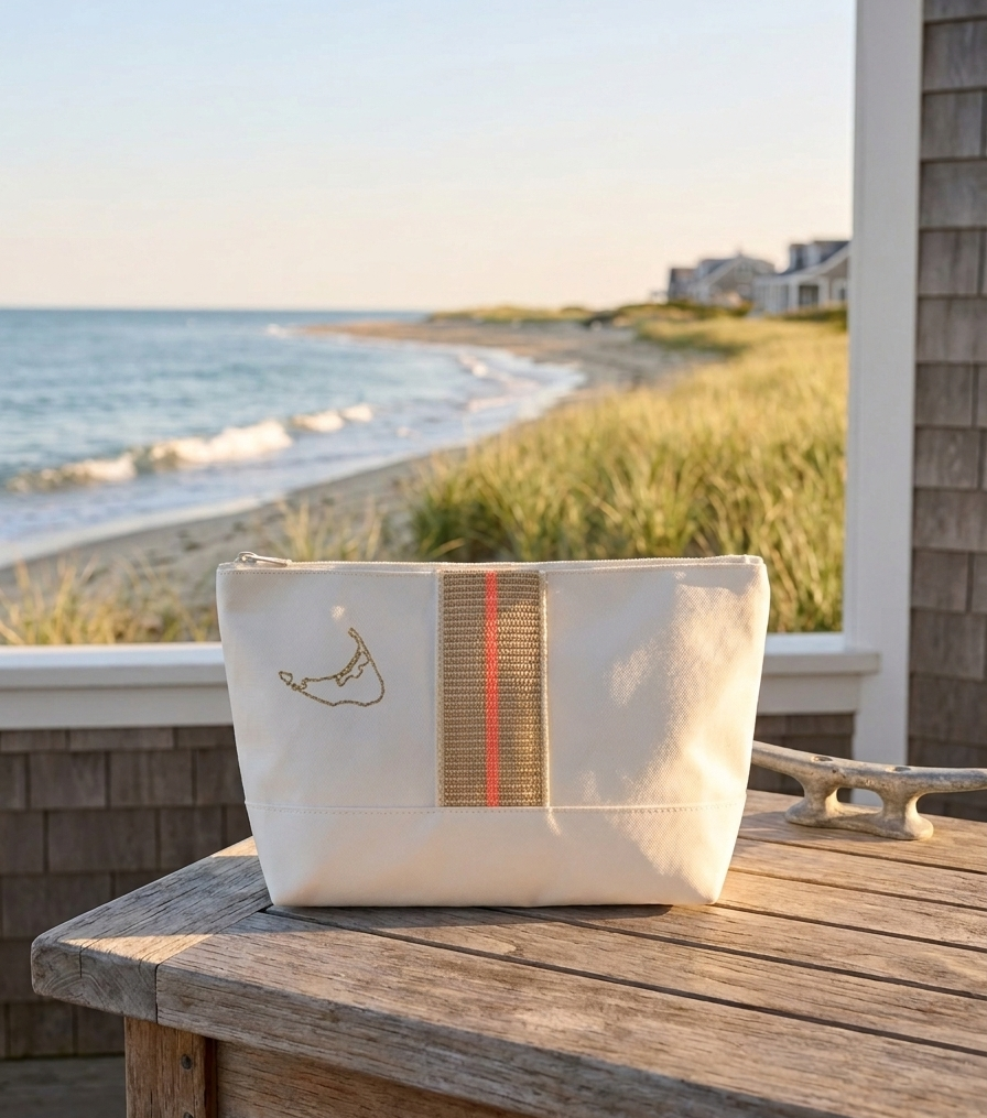 White pouch with a striped pattern on a wooden table by the beach