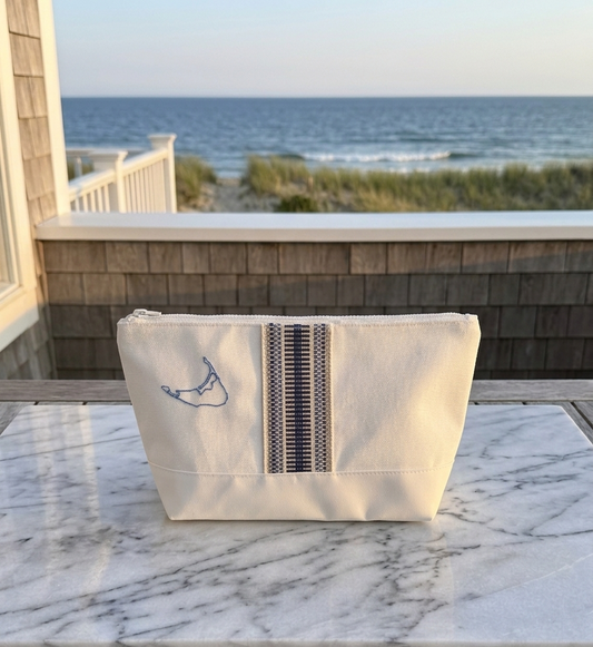 Beige pouch with a zipper on a marble surface with ocean view